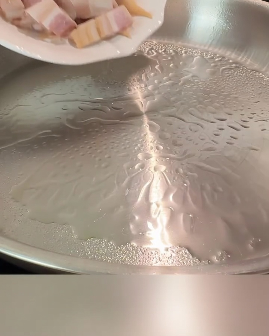 달궈진 팬에서 베이컨 조각들이 노릇하게 익어가는 모습.