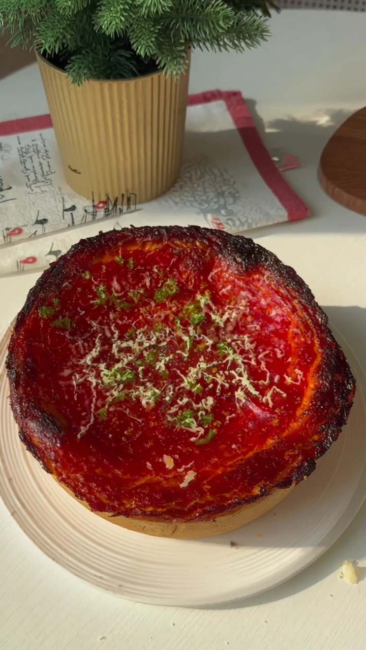 원형 틀에 구워 토마토소스, 치즈, 신선한 파슬리를 올린 시카고 딥디시 피자.