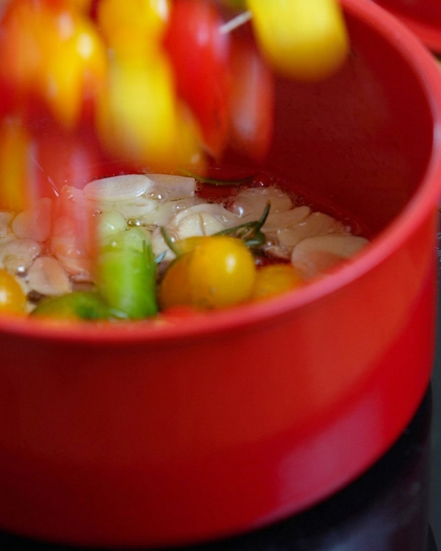 달궈진 오일에 반으로 자른 토마토를 넣는 모습