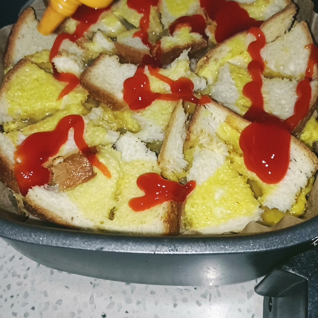 조리된 식빵과 달걀 베이스 위에 붓으로 토마토 소스를 펴 바르는 모습.