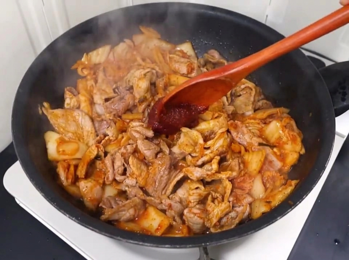 고추장과 고춧가루를 넣고 볶고 있는 모습.
