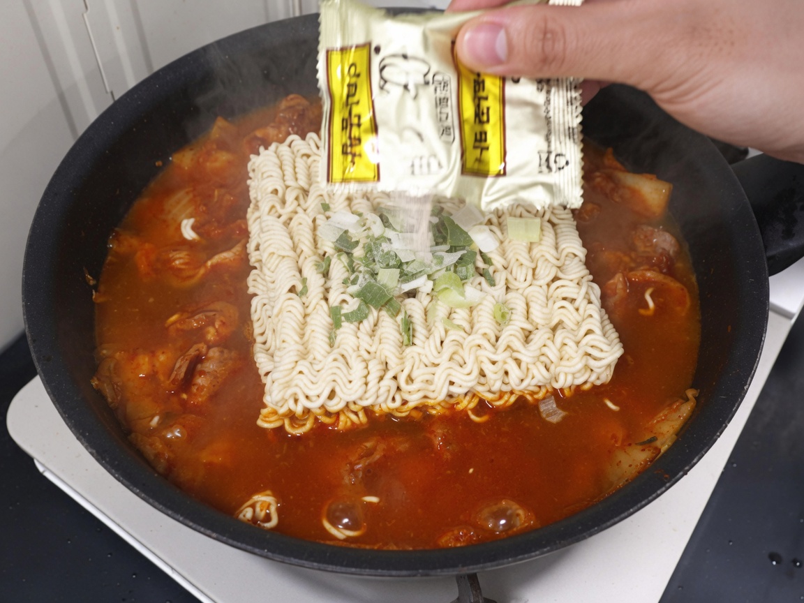 라면 스프와 건더기 스프를 넣는 모습.