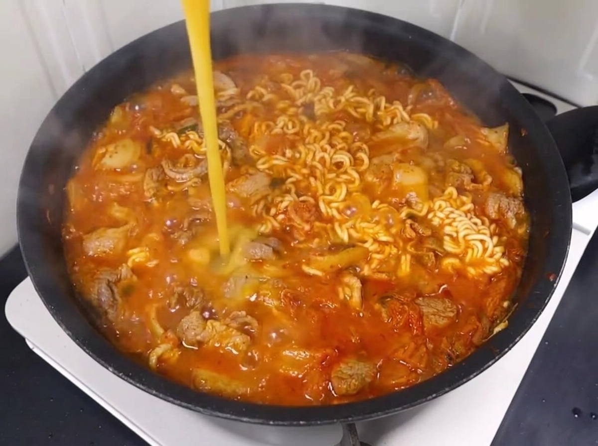 끓는 라면에 푼 계란을 붓는 모습.