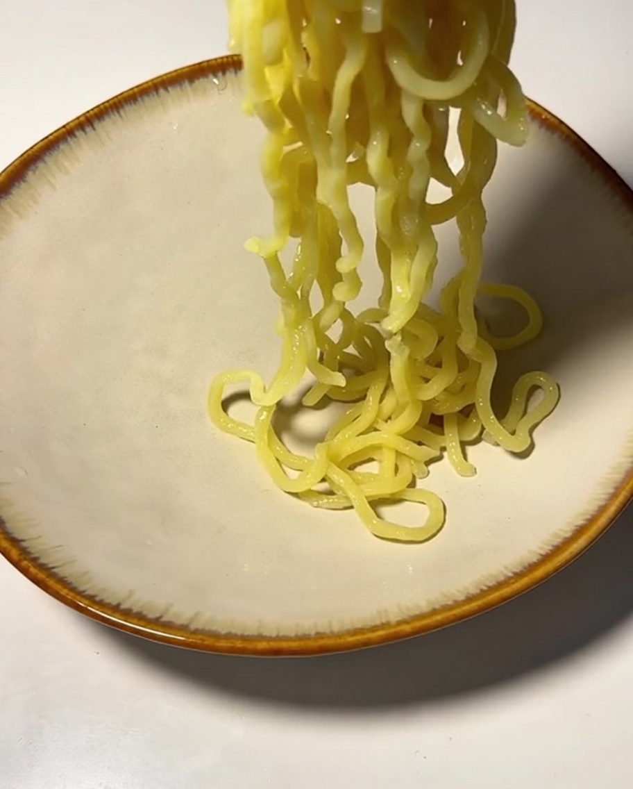 삶은 면을 그릇에 담는 모습.