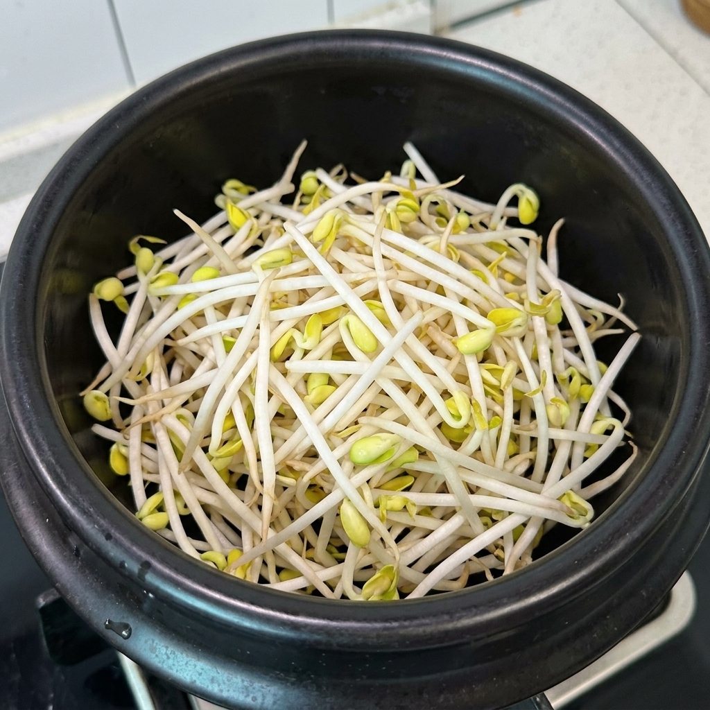 뚝배기에 콩나물과 살코기를 담는 모습.