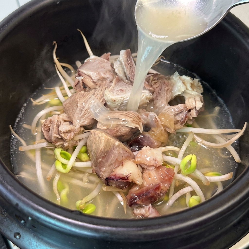 뚝배기에 뽀얀 육수를 붓는 모습.