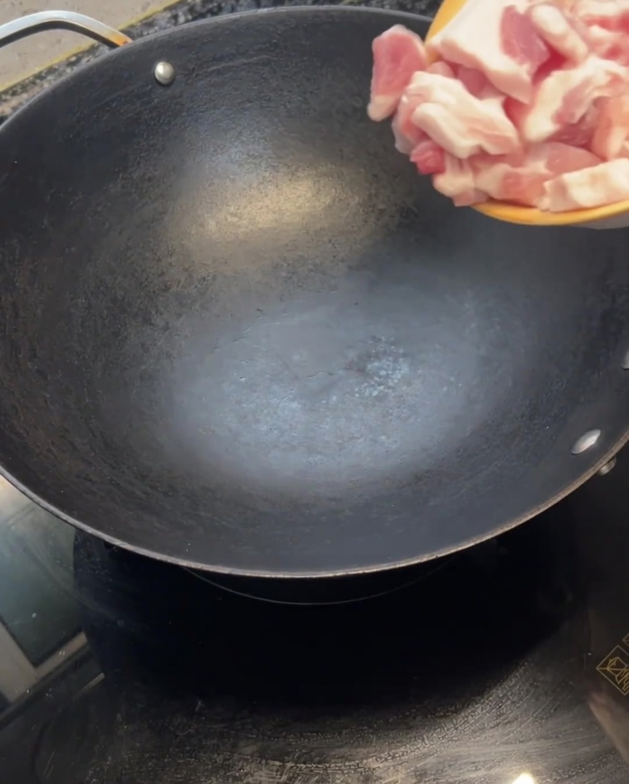 뜨겁게 달궈진 빈 웍에 썰어둔 삼겹살을 넣는 모습.