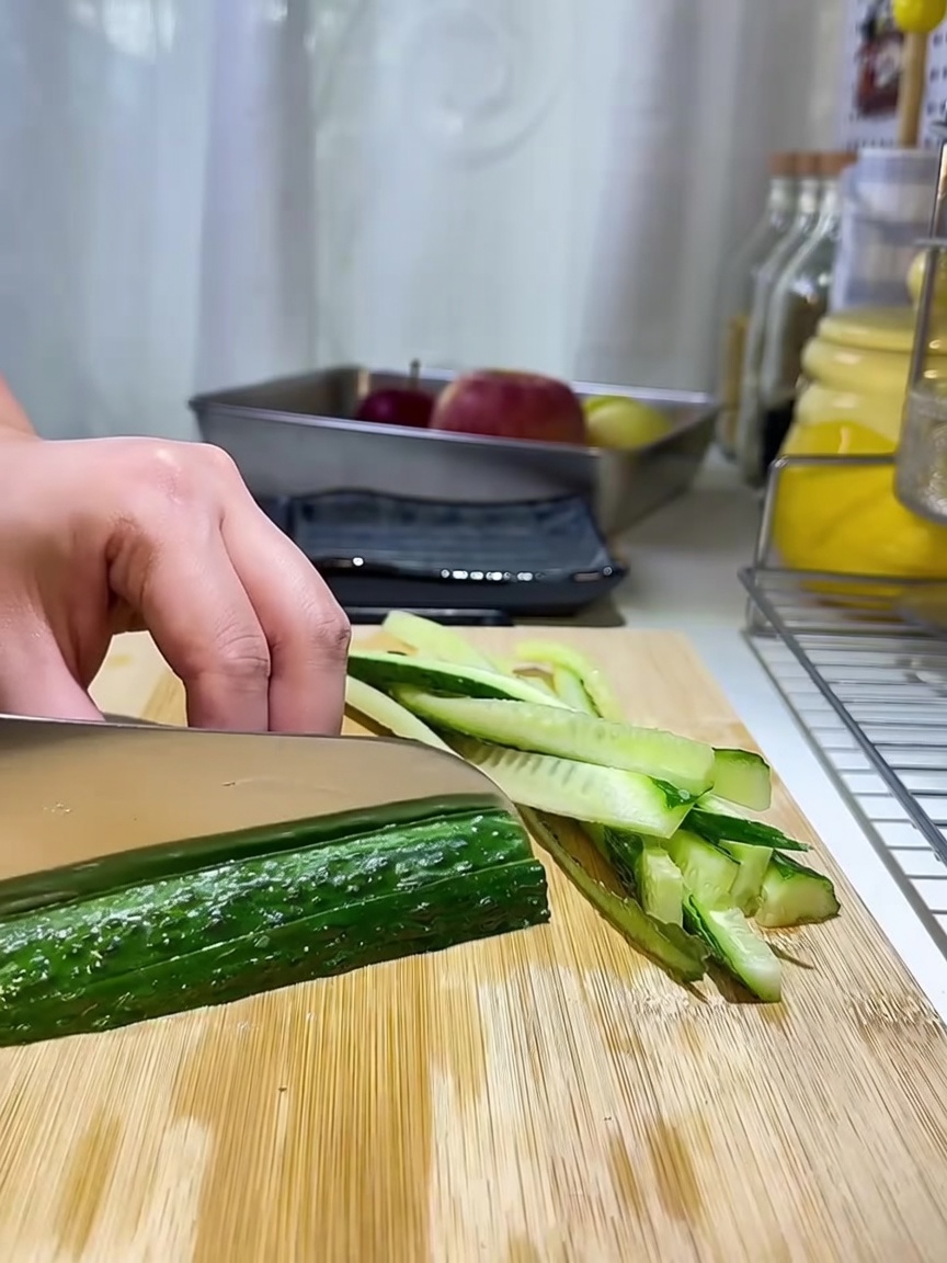 나무 도마 위에 가지런히 썰어놓은 오이 채.