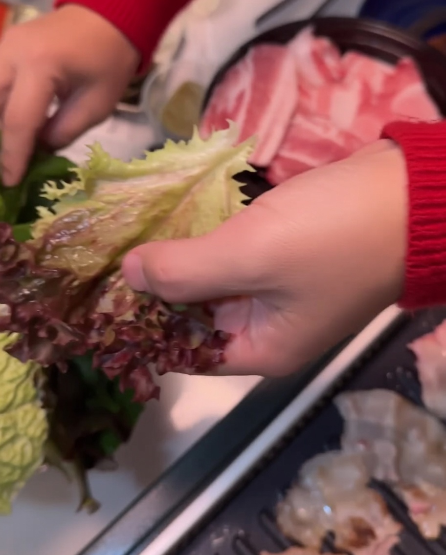 손바닥 위에 상추와 깻잎을 겹쳐 올린 모습.
