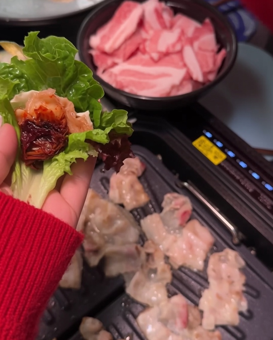 쌈 채소 위의 고기에 쌈장을 살짝 바르는 모습.