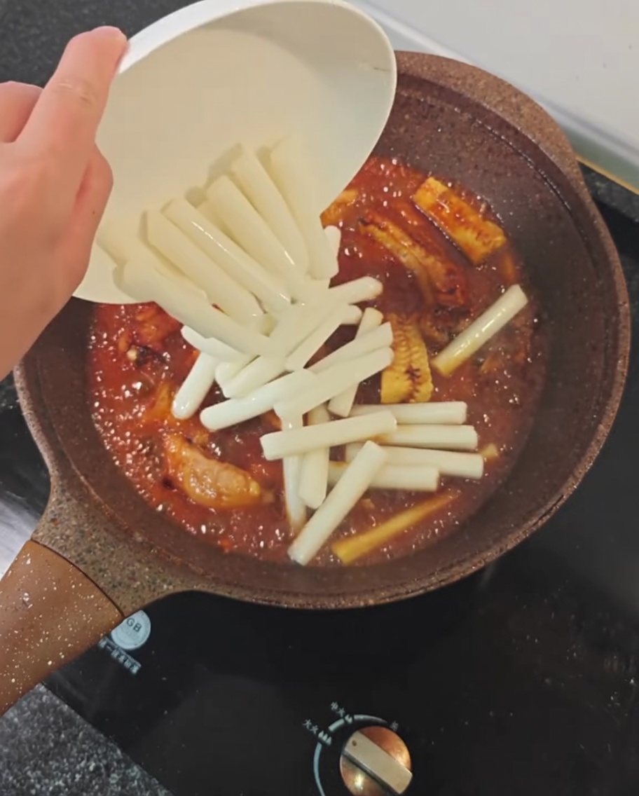 양념이 잘 밴 갈비찜에 떡을 넣는 모습.