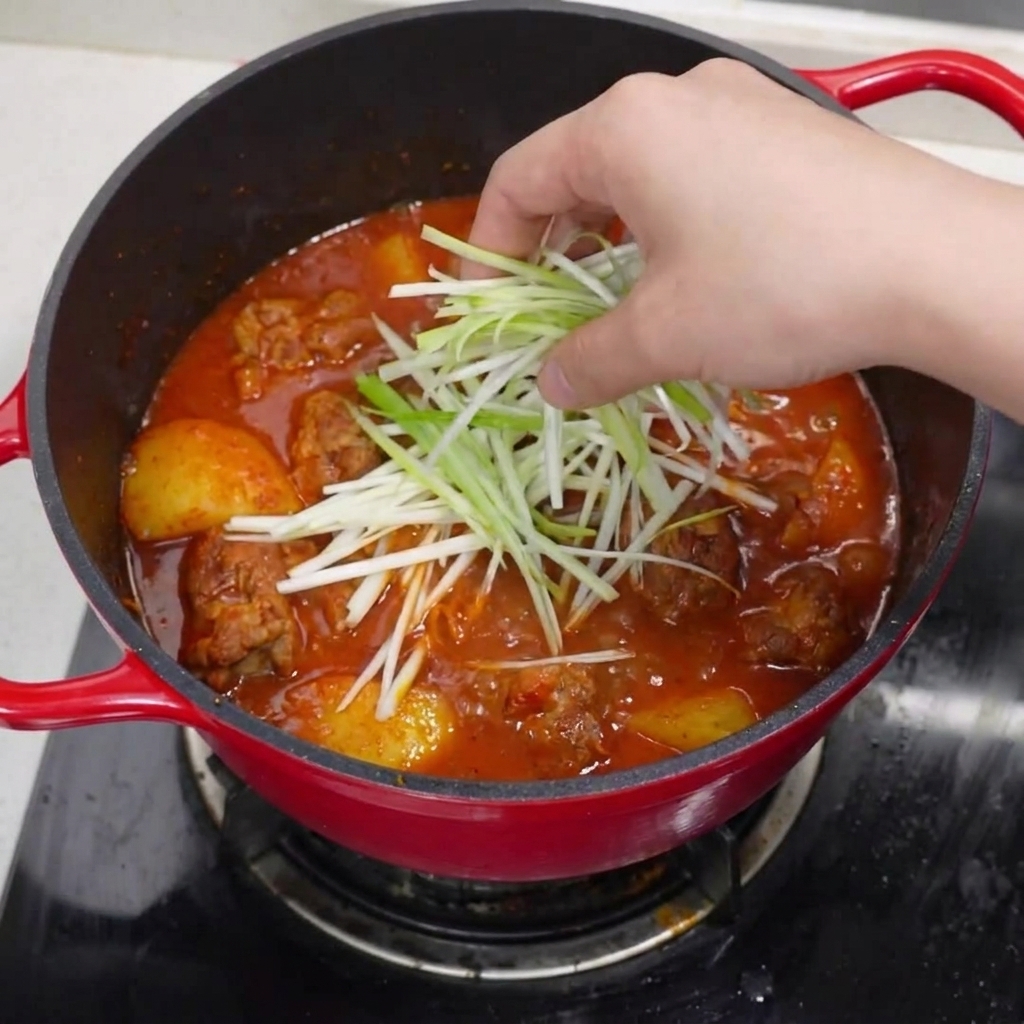 완성된 갈비찜에 대파와 고추를 뿌려 마무리하는 모습