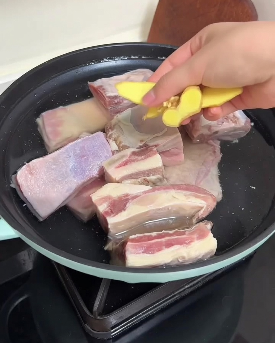 냄비에 생강 편과 갈비를 넣고 데치는 모습.