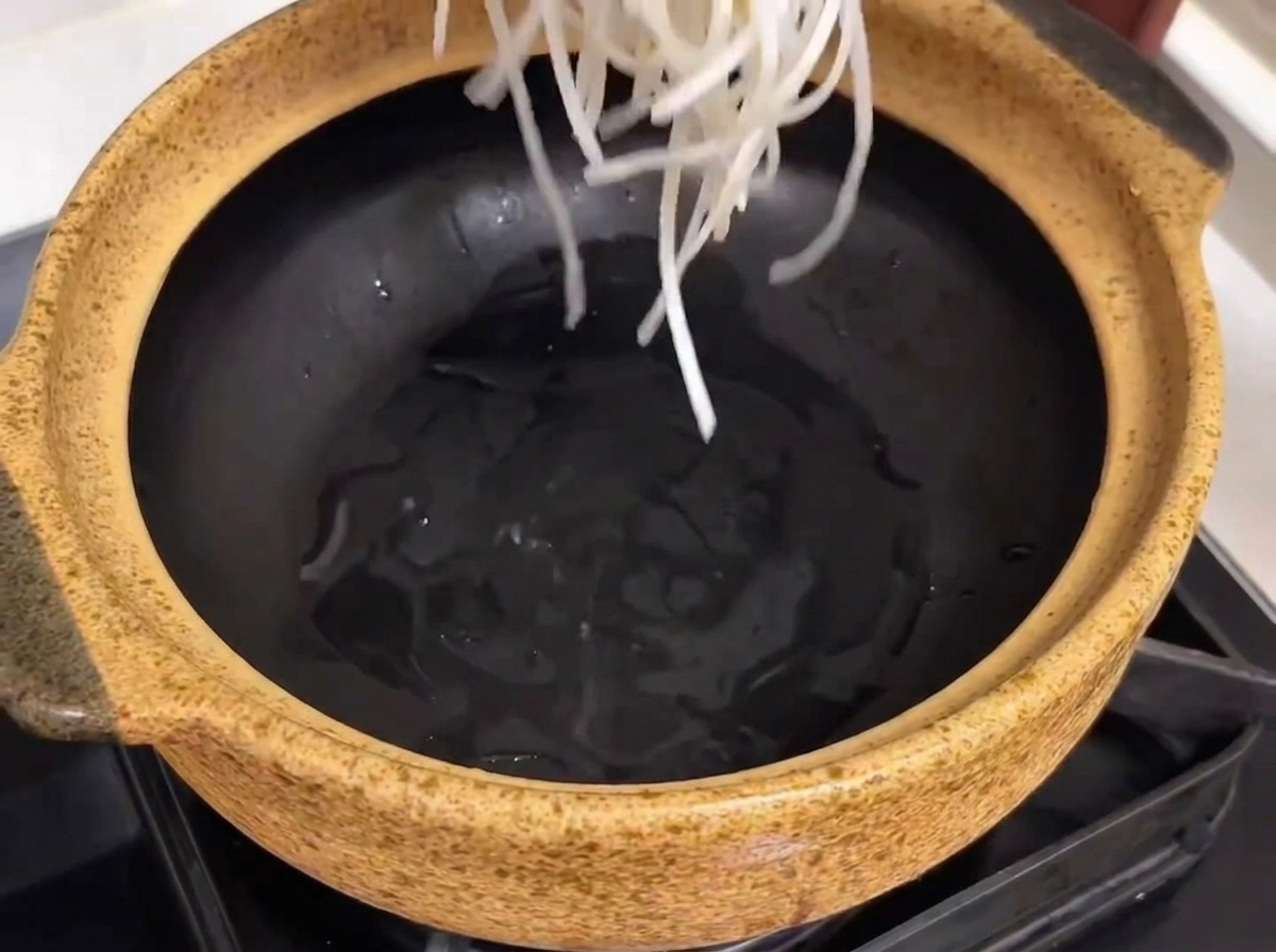 그릇 바닥에 당면을 깔고 그 위에 갈비와 무를 올린 모습.