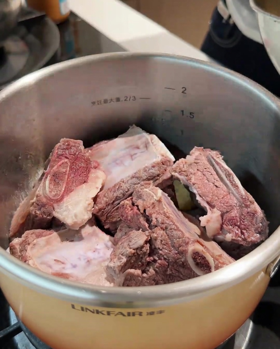 볶아진 향채에 데친 소갈비와 다양한 통향신료들을 넣는 모습.