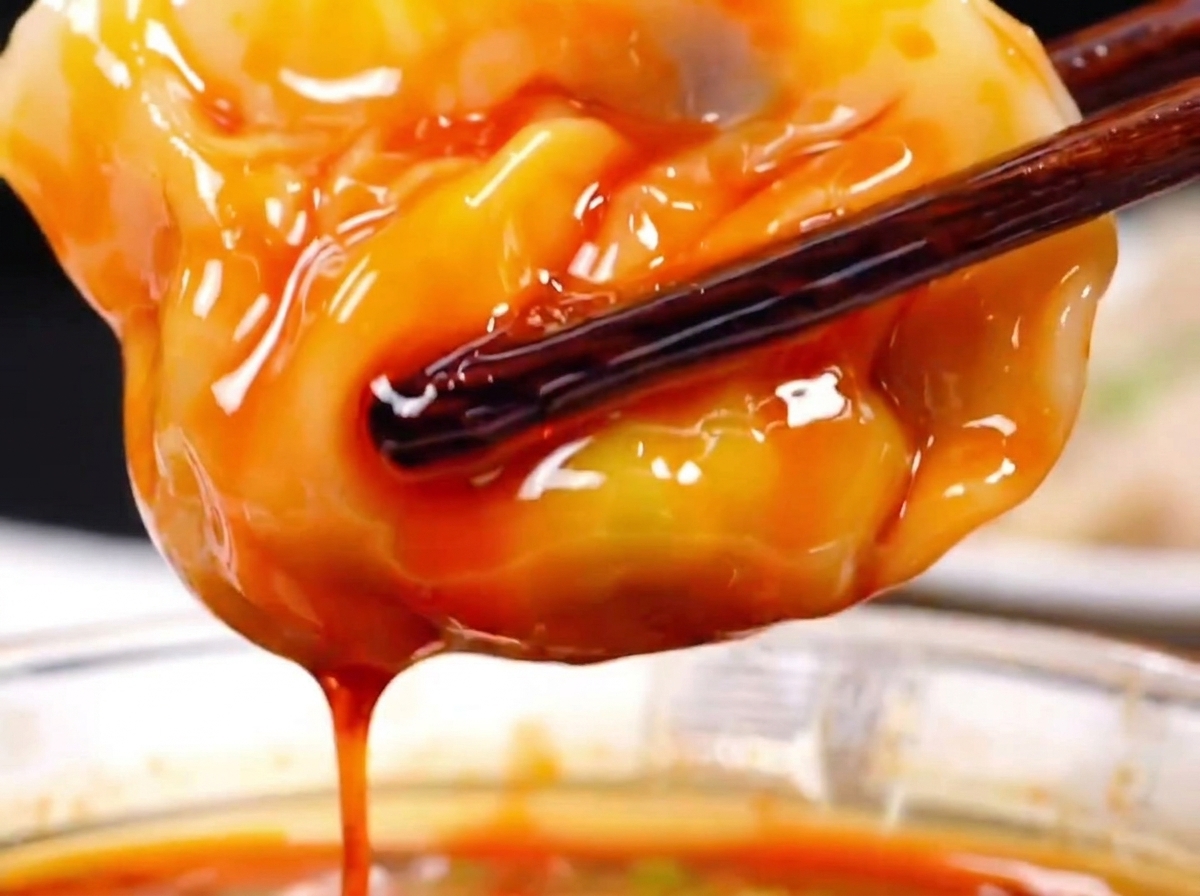 도마 위에서 정밀한 각도 칼집으로 썰리고 있는 삼겹살의 근접 샷.