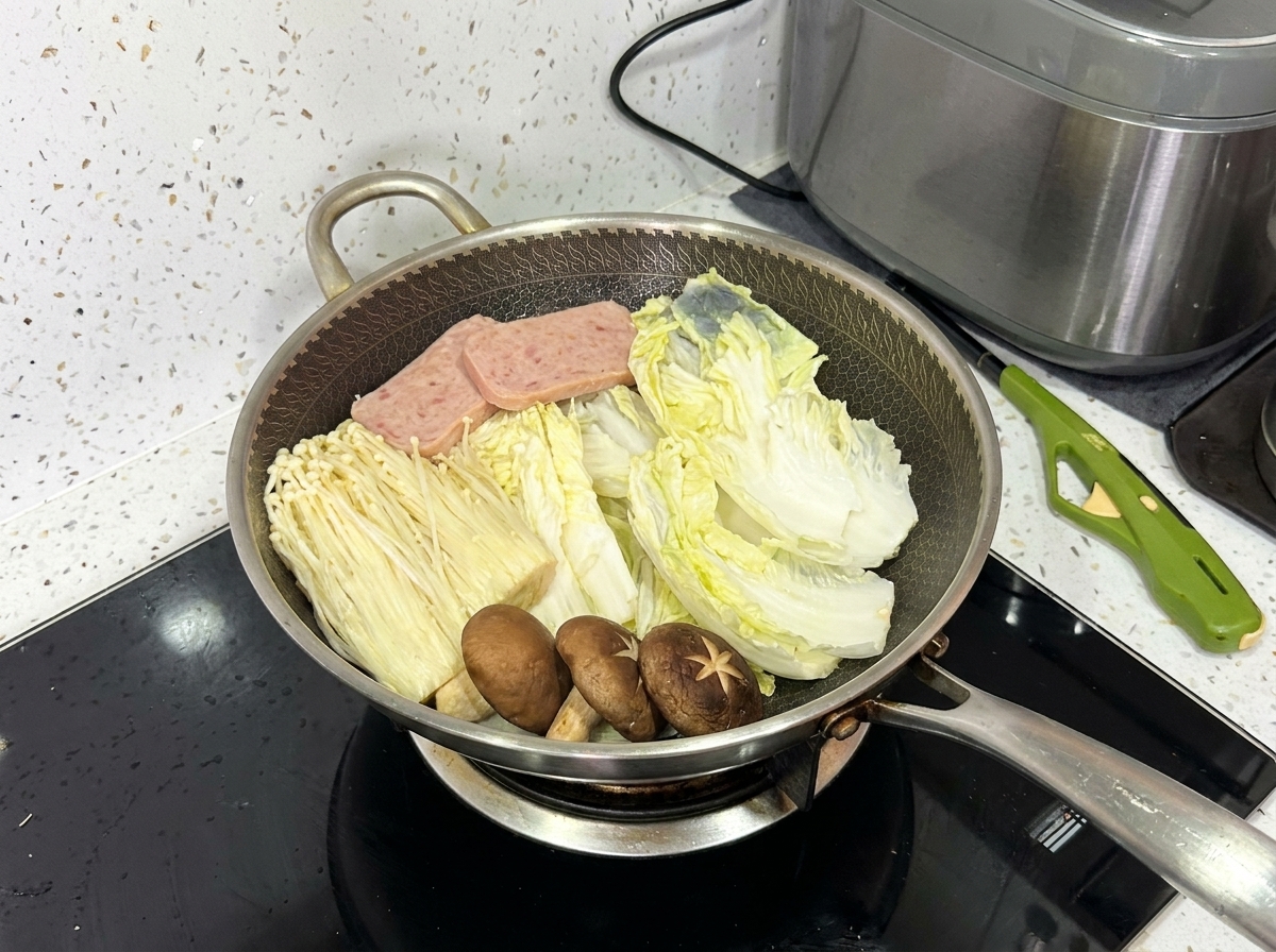 배추, 팽이버섯, 표고버섯, 런천미트, 돼지고기 슬라이스가 완전히 세팅된 냄비.