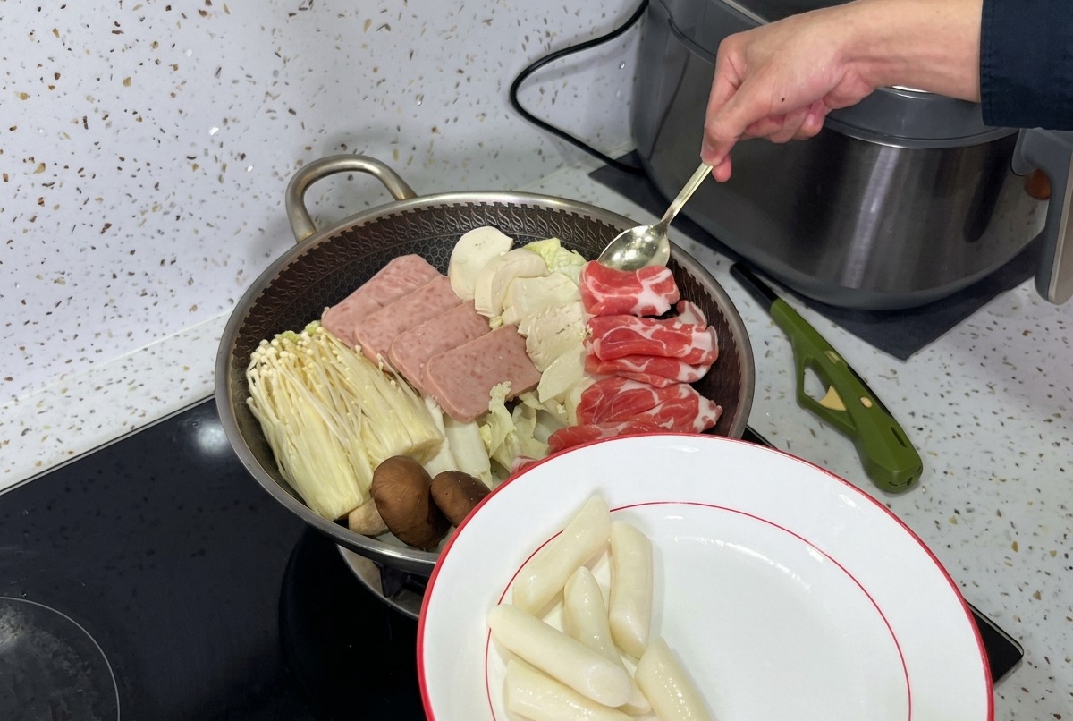 국물을 부어 끓일 준비가 된 런천미트, 버섯, 두부, 신김치 레이어가 어우러진 아름다운 부대찌개 전골 냄비.