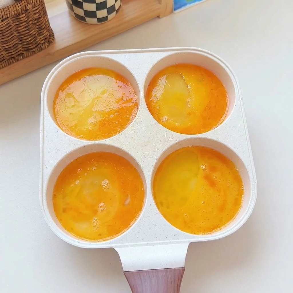 팬 안의 계란물 위에 새우, 햄, 다진 고기, 옥수수 토핑이 추가된 모습.