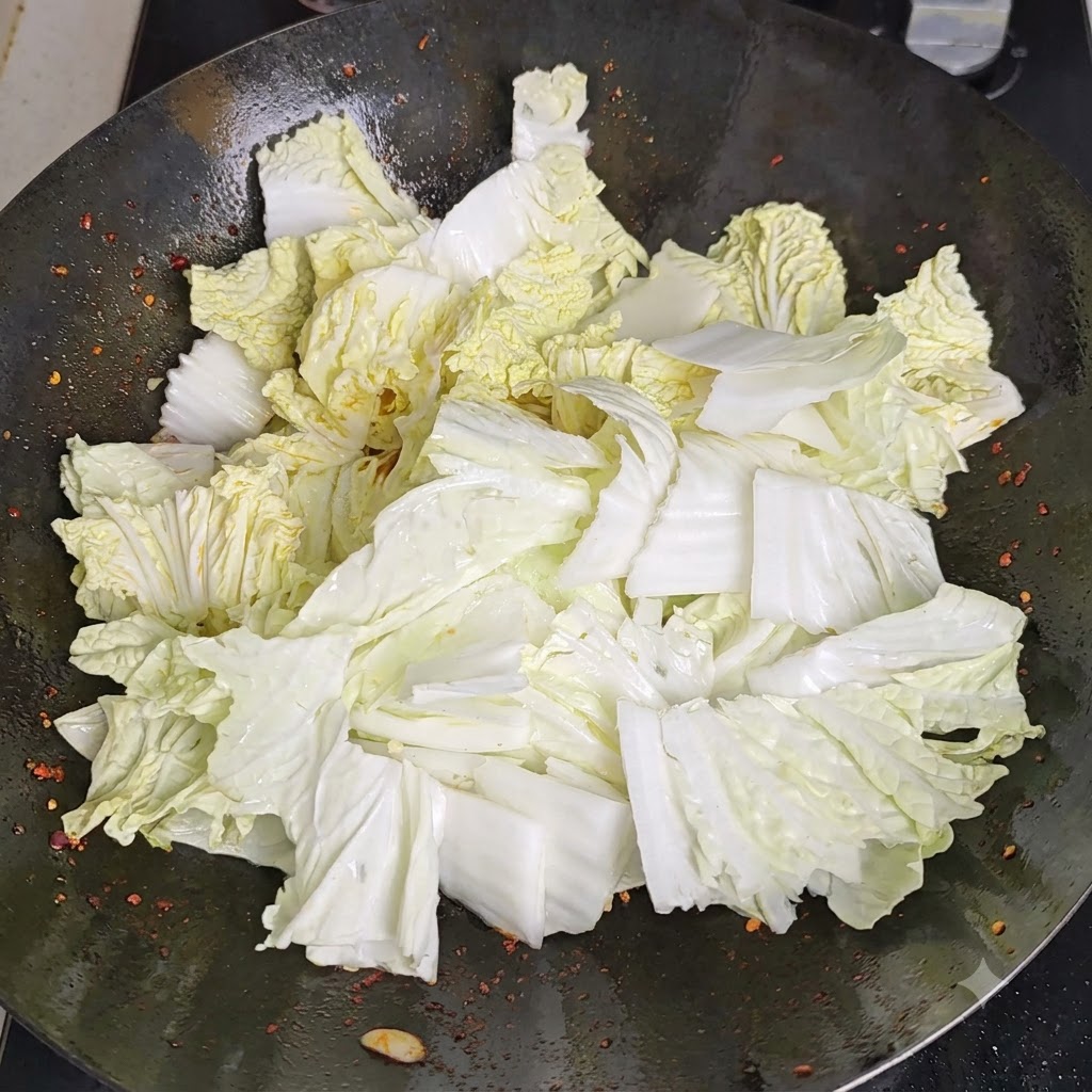 뜨겁게 달궈진 웍의 안쪽 테두리를 따라 식초를 부어 열기에 반응하는 모습.