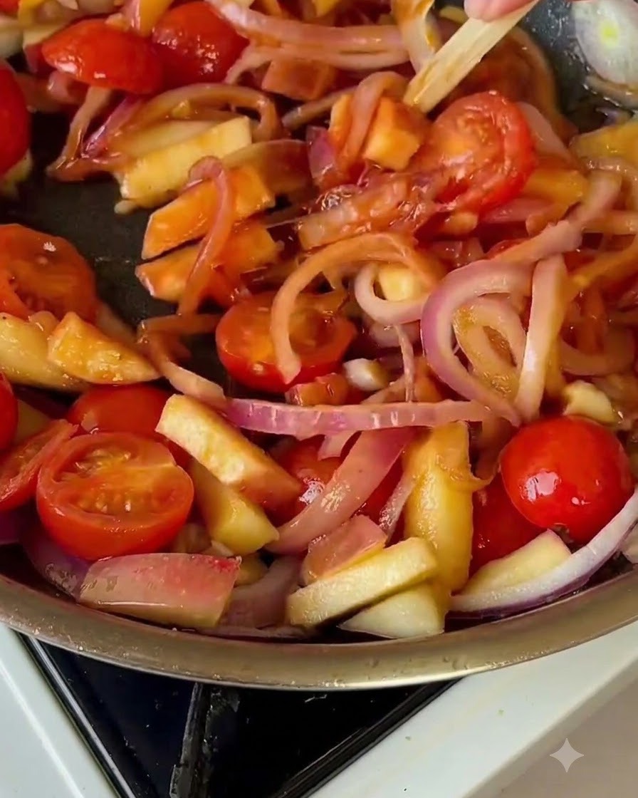토마토와 양파가 있는 팬에 배추가 섞여 있는 모습.