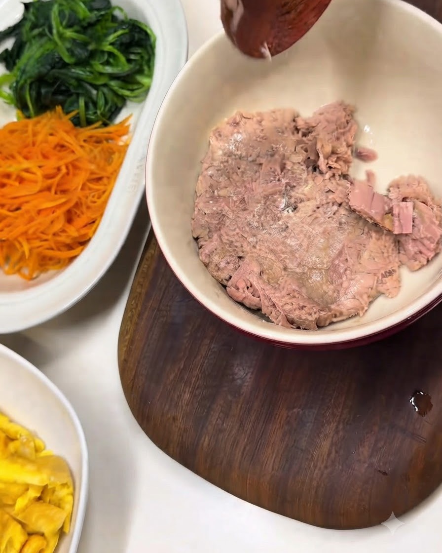 삶은 시금치와 당근이 담긴 흰색 접시 옆에 놓인 기름 뺀 참치 그릇.