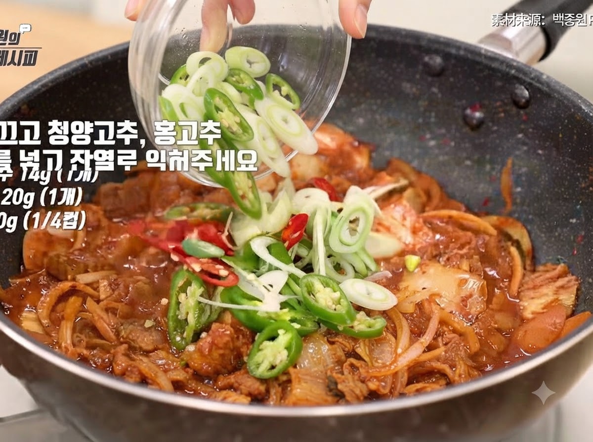 썰어둔 대파, 고추, 참기름을 볶은 재료에 넣고 섞는 모습.