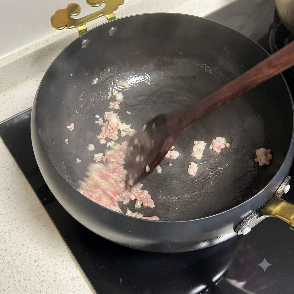 팬에서 함께 볶아지고 있는 다진 적양파와 썬 토마토의 모습.