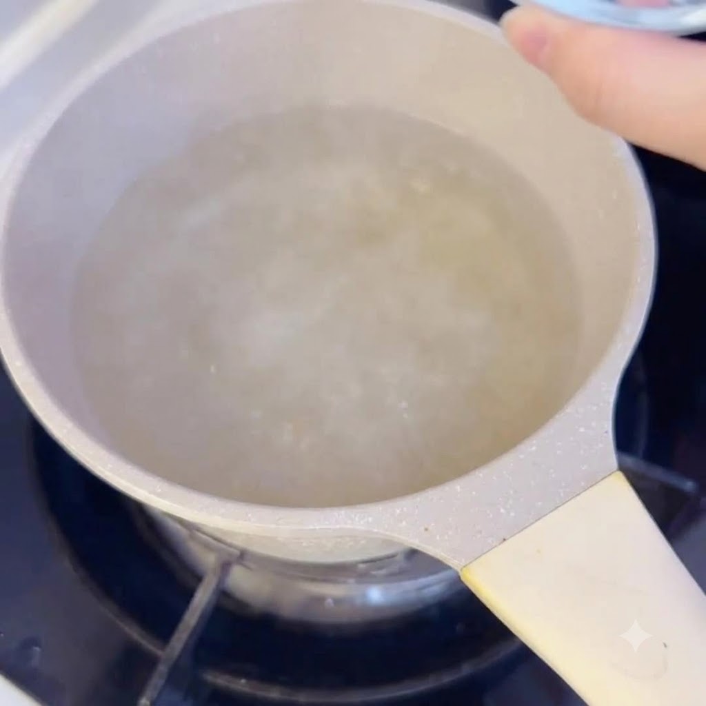팔팔 끓는 육수가 담긴 냄비 속으로 떡국떡을 넣고 있는 모습.