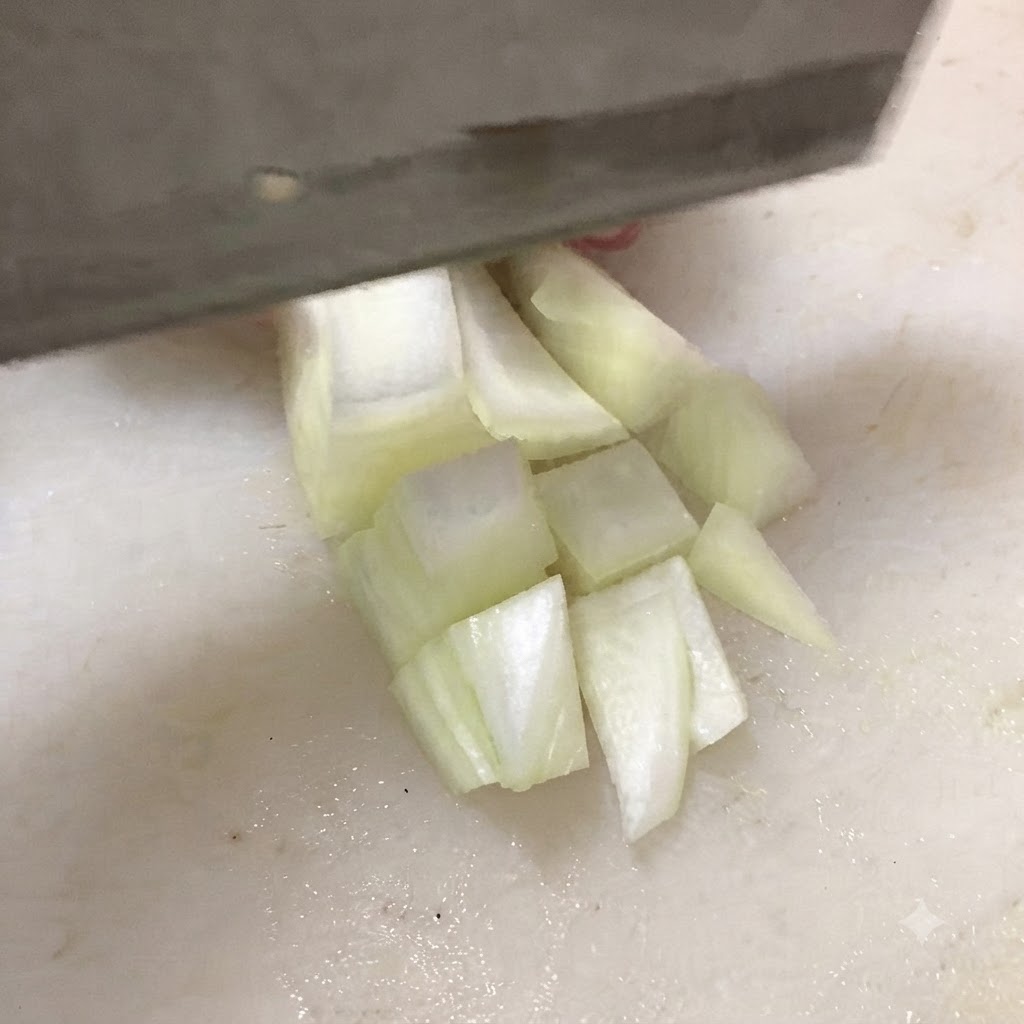 하얀 도마 위에서 단단한 두부를 도톰한 네모 모양으로 썰고 있는 모습.