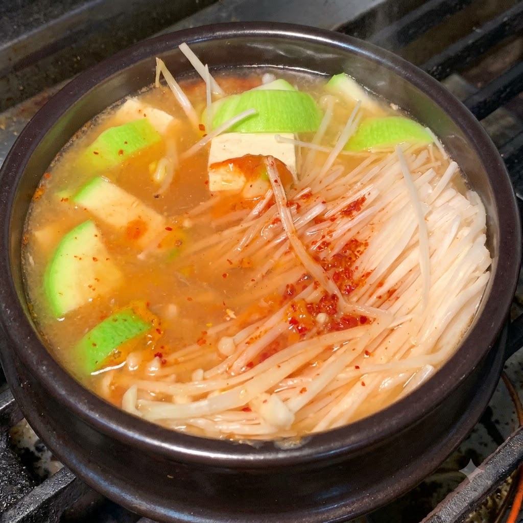 양념 육수에 재료들이 어우러져 끓고 있는 뚝배기 클로즈업 사진.