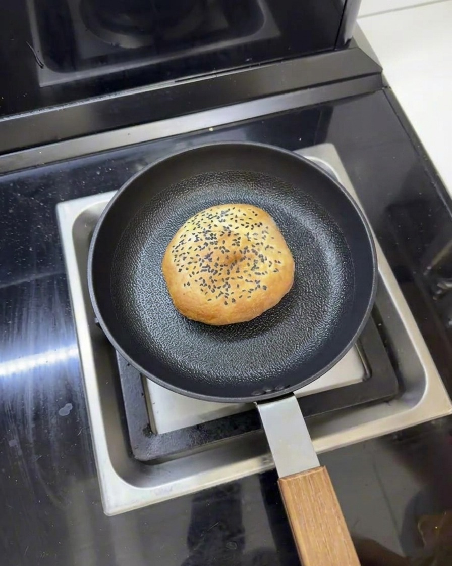 프라이팬에 담긴 버터 버거 번과 주변의 물, 뚜껑을 덮어 찌기 직전의 모습.