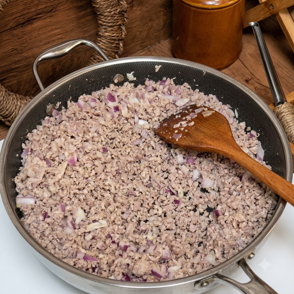 갈아놓은 고기와 양파가 볶아진 팬 위로 신선한 토마토와 토마토 퓌레 통조림이 부어지는 모습.