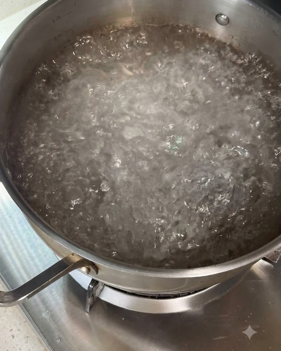 조리 도구를 사용하여 끓는 물 냄비에 마른 파스타를 저어 넣는 모습.