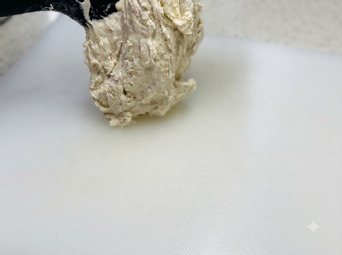주걱으로 들어 올려 오일이 뿌려진 하얀 도마 위에 올려지는 고수분 끈적한 반죽.