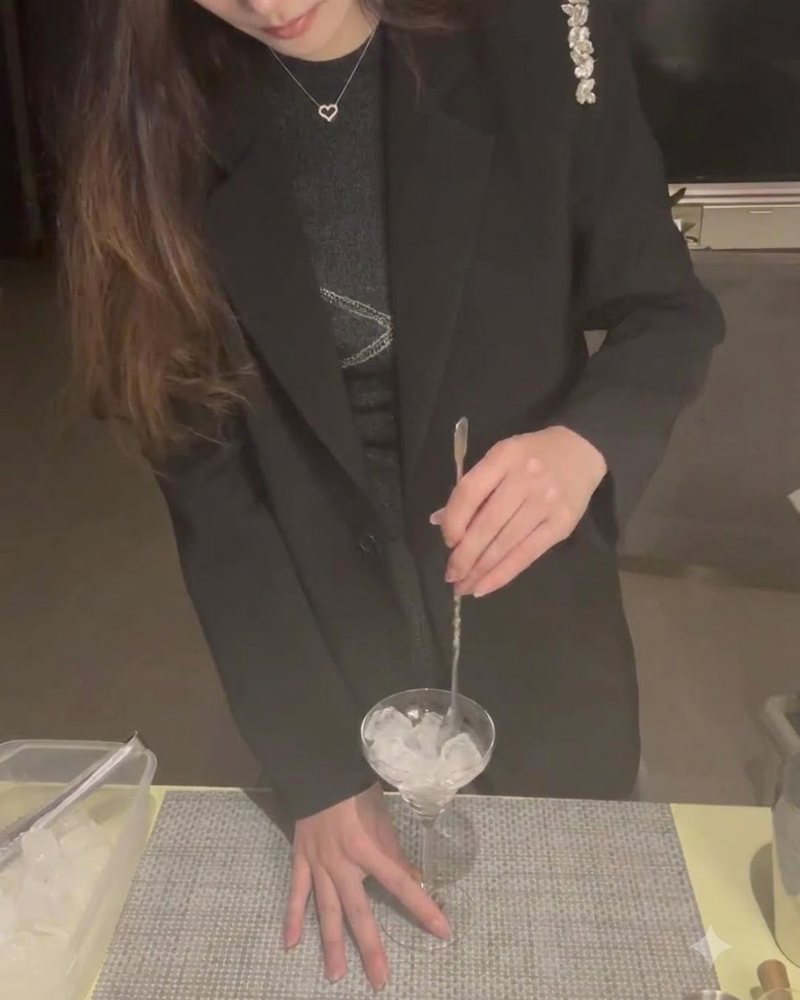 마티니 잔에 얼음을 넣고 칵테일 스푼으로 저어 차갑게 만드는 모습