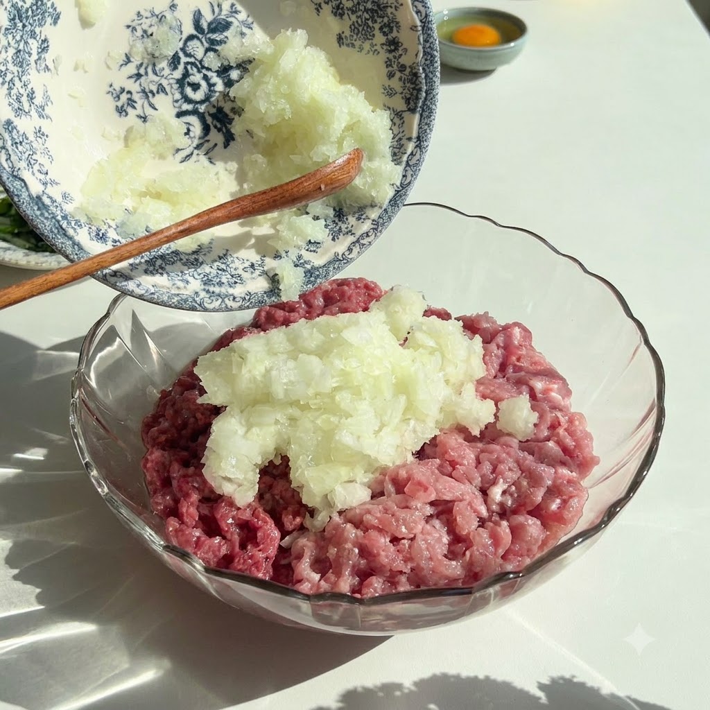 곱게 다진 양파와 파슬리가 장식용 그릇에서 생고기가 담긴 유리 볼로 부어지는 모습.