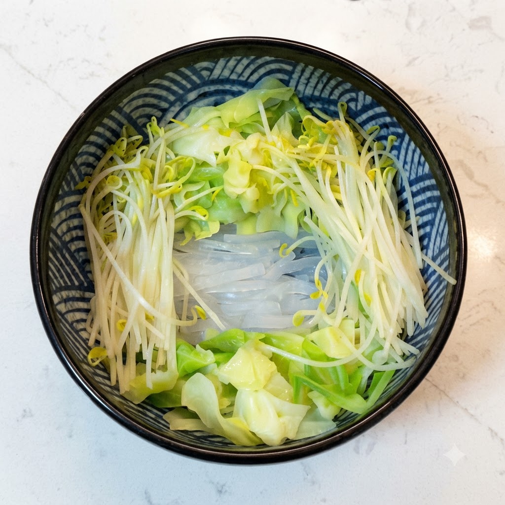 데친 야채들이 둘러싸고 있는 그릇 속에 담긴 조리된 메밀국수.