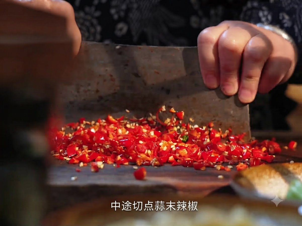 나무 도마 위에서 중식 칼로 썰고 있는 신선한 홍고추.
