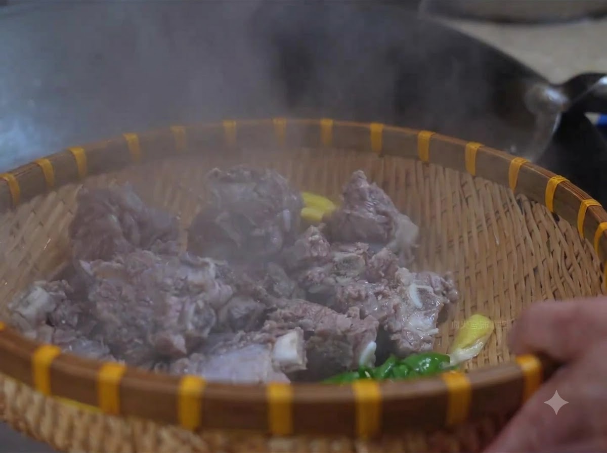 대나무 바구니에 담긴 데친 소갈비를 미지근한 물로 헹구는 모습.