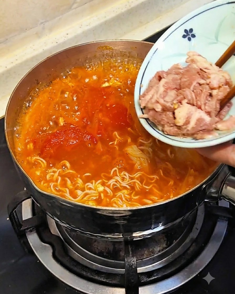 작은 접시에 담긴 얇은 고기를 젓가락으로 뜨거운 육수 속에 넣는 모습.
