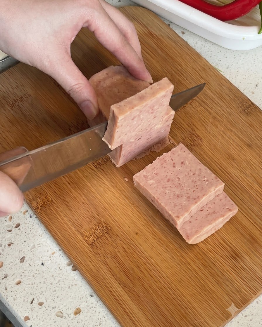도마 위에서 두껍게 썰리고 있는 통조림 런천미트.