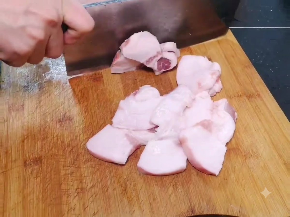 나무 도마 위에서 얇고 넓은 형태로 썰리고 있는 생고기 조각들.
