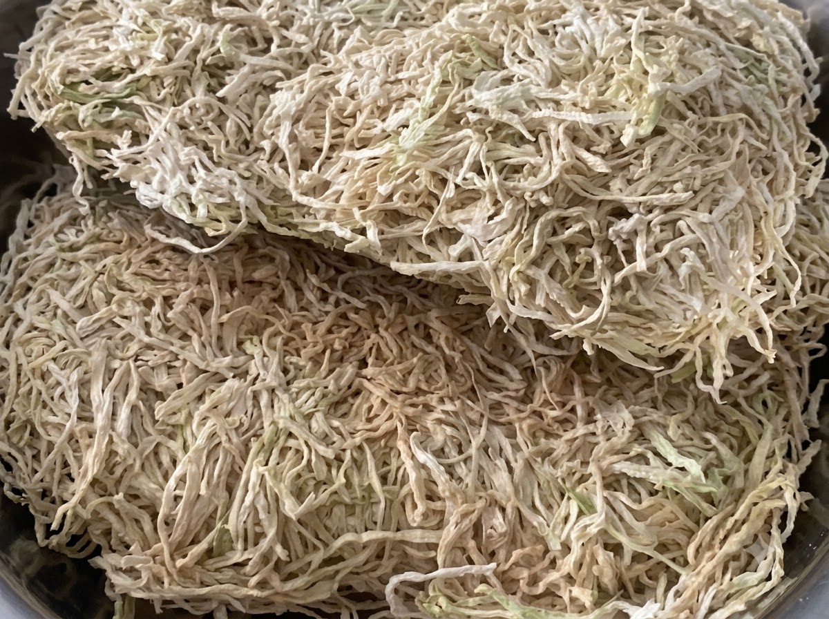 금속 용기 안에 수북하게 쌓인 건조 무말랭이의 근접 뷰.