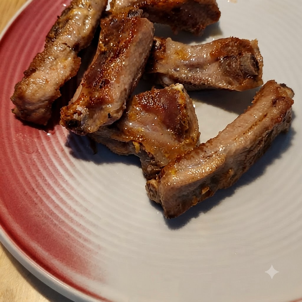 팬에 노릇하게 구워진 돼지갈비 위로 커피 소스가 부어지는 모습.