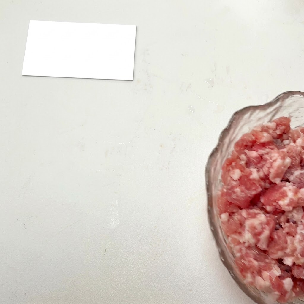 유리 볼에 담긴 다진 고기에 각종 양념이 추가되는 모습.