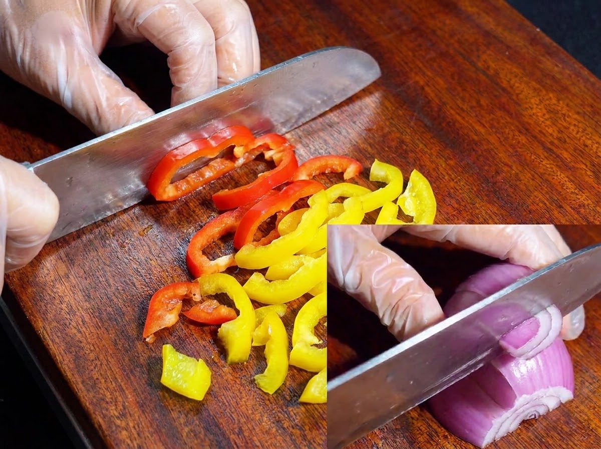 나무 도마 위에서 알록달록한 피망과 적양파를 썰고 있는 칼.