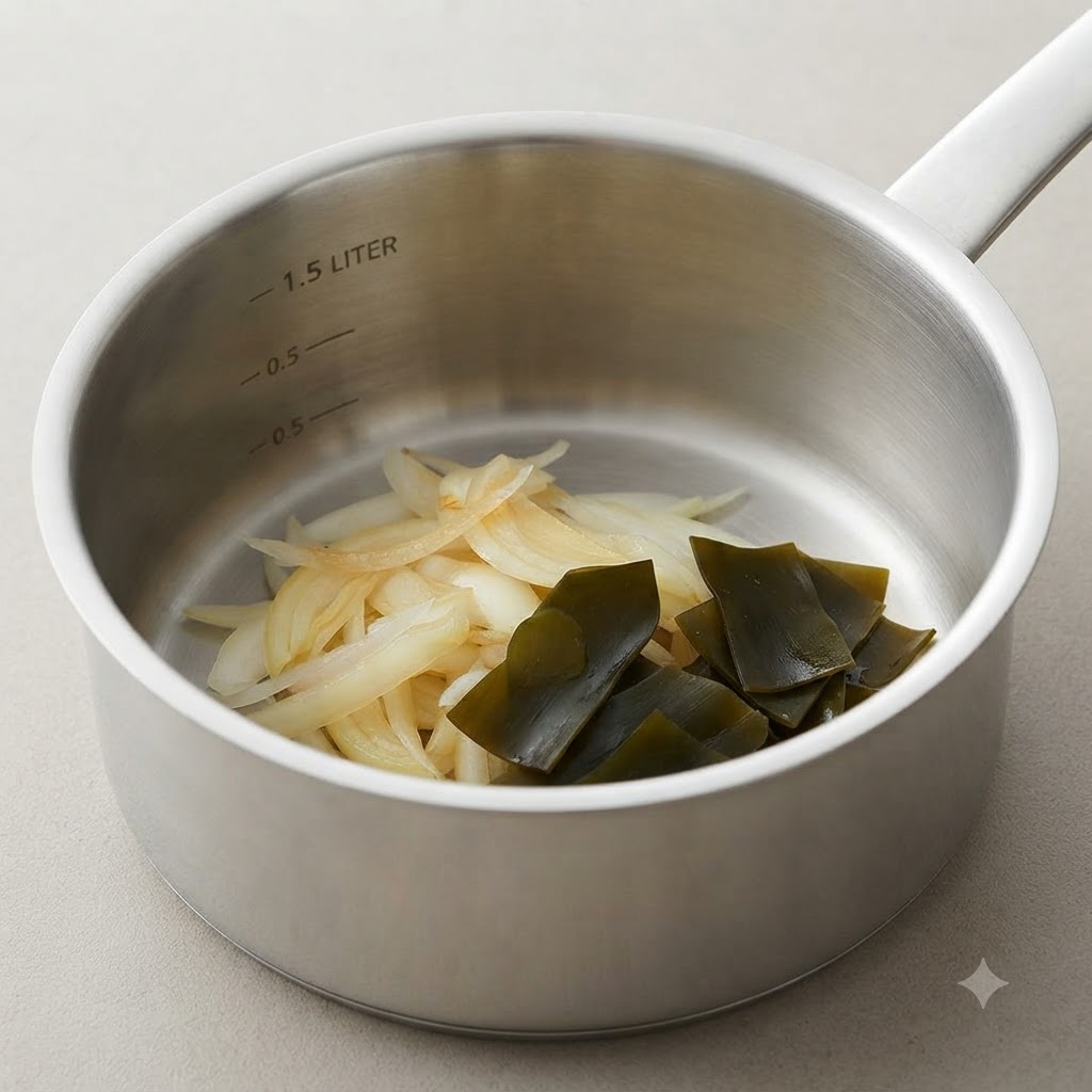 부드럽게 익은 양파와 접힌 다시마 매듭이 들어 있는 요리 냄비.