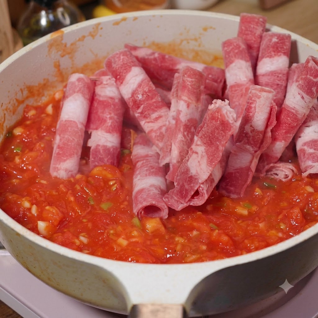 토마토가 든 팬에 얇게 썬 소고기를 넣고 함께 볶아내는 모습.