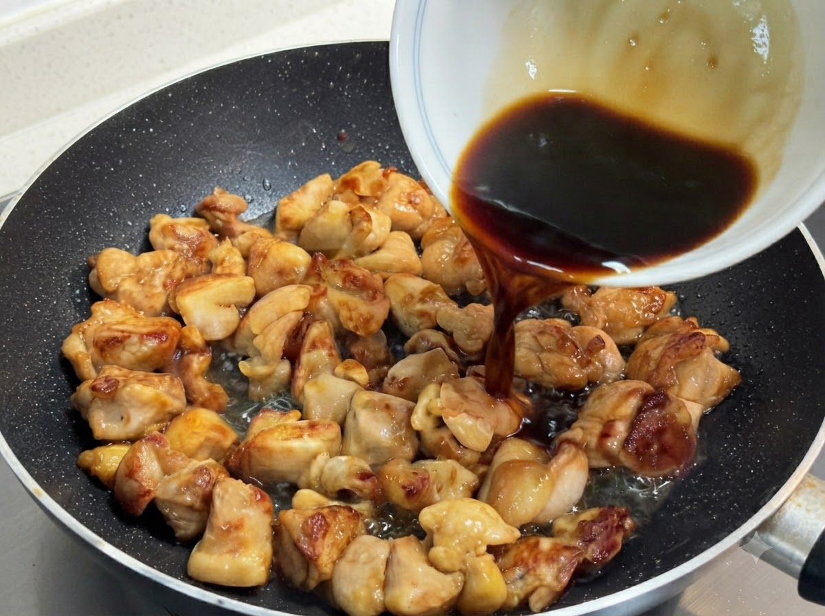노릇하게 구워진 닭고기 위로 작은 그릇에 담긴 짙은 색의 특제 소스를 붓는 모습.